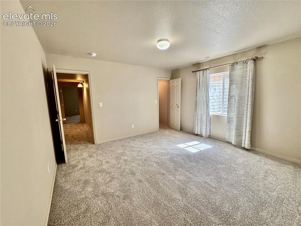 Image 23 of 39: Spacious room featuring neutral carpeting and light-toned walls