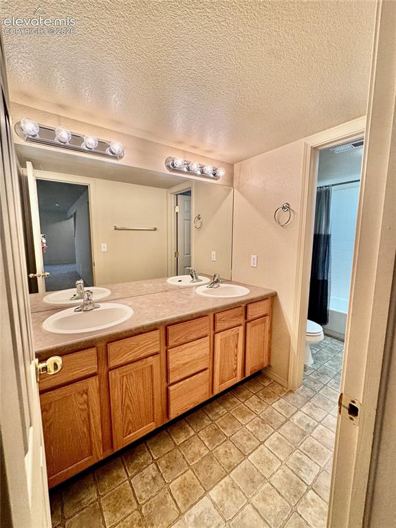 Image 26 of 39: Bathroom featuring a double vanity with light wood cabinetry and a neutral-