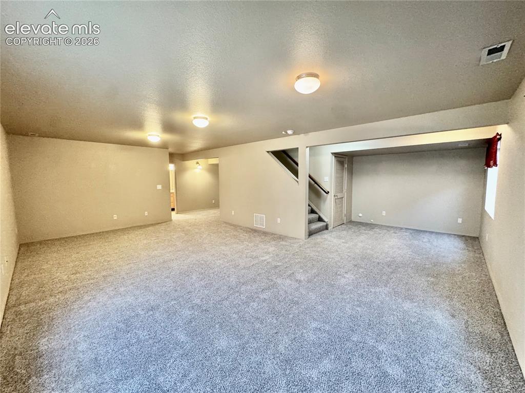 Image 28 of 39: Spacious carpeted room featuring neutral-toned walls, recessed lighting, an