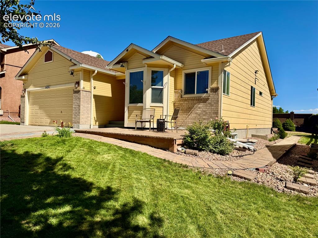 Image 3 of 39: Siding exterior with brick accents, an attached two-car garage, and a front