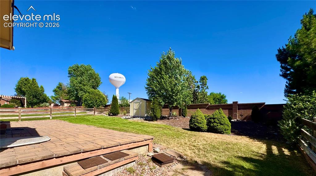 Image 37 of 39: Expansive backyard featuring a stone paver patio, a manicured lawn, mature