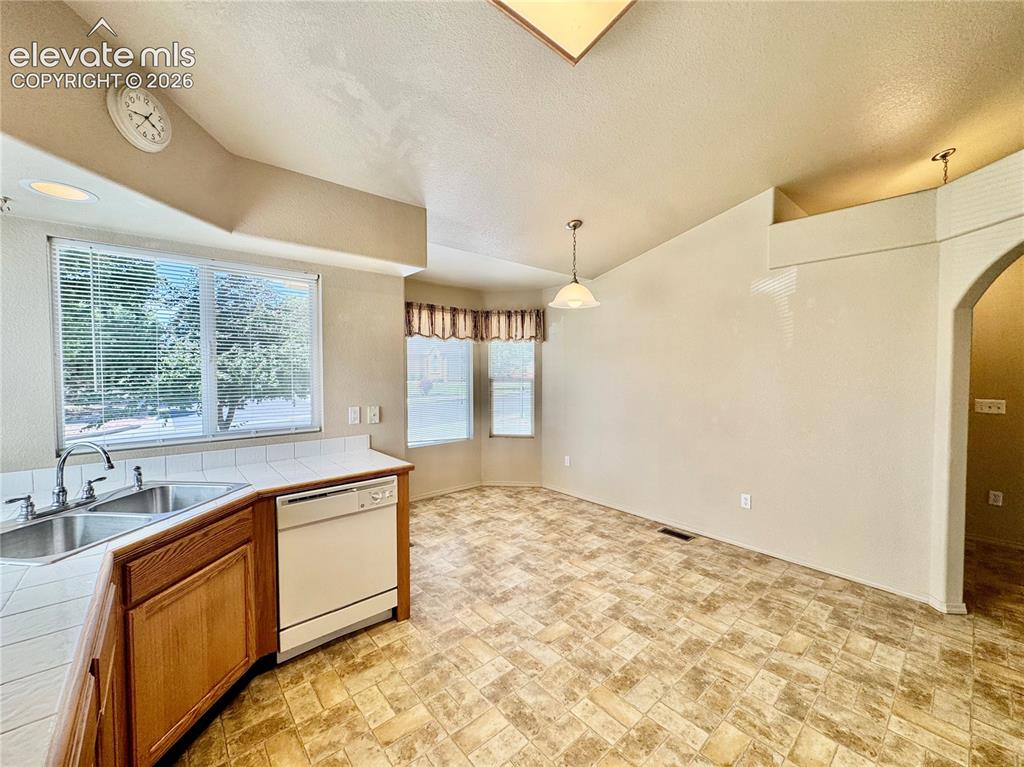 Image 7 of 39: Kitchen and dining area featuring a double basin stainless steel sink, a wh