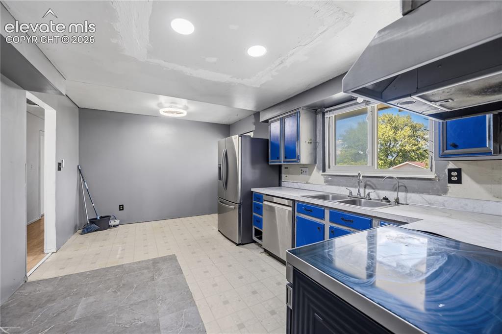 Image 10 of 35: Kitchen with stainless steel appliances, dual-basin sink, overhead cabinetr