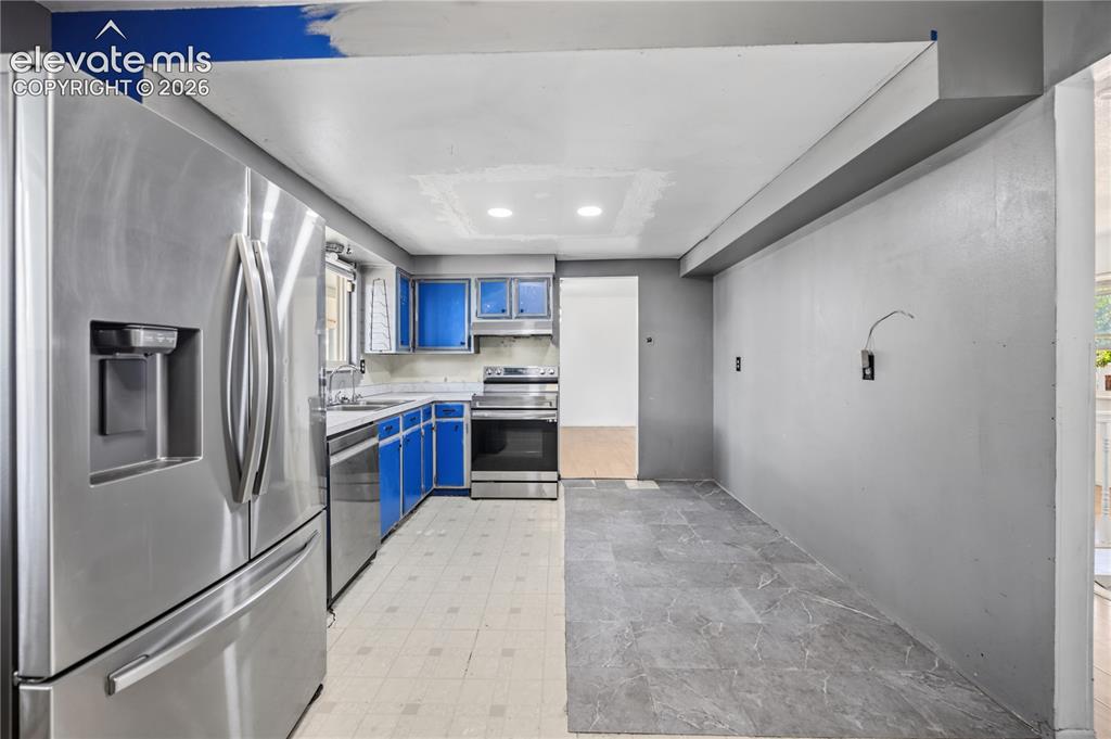 Image 11 of 35: Kitchen featuring stainless steel appliances including a refrigerator, rang