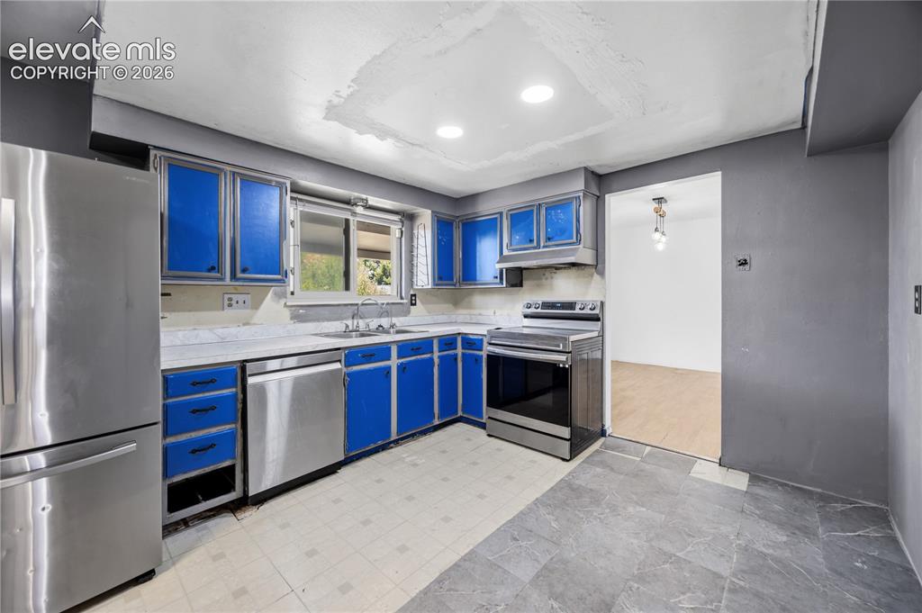 Image 12 of 35: Kitchen featuring stainless steel appliances, blue cabinetry, a double basi