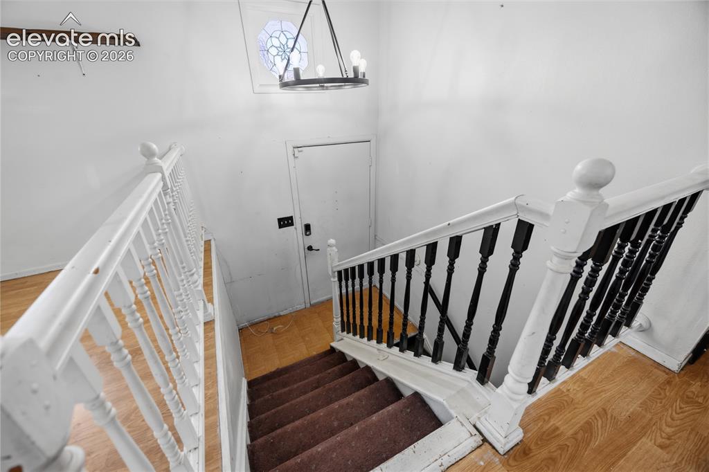 Image 14 of 35: Staircase featuring wood-finish flooring, a decorative stained-glass window