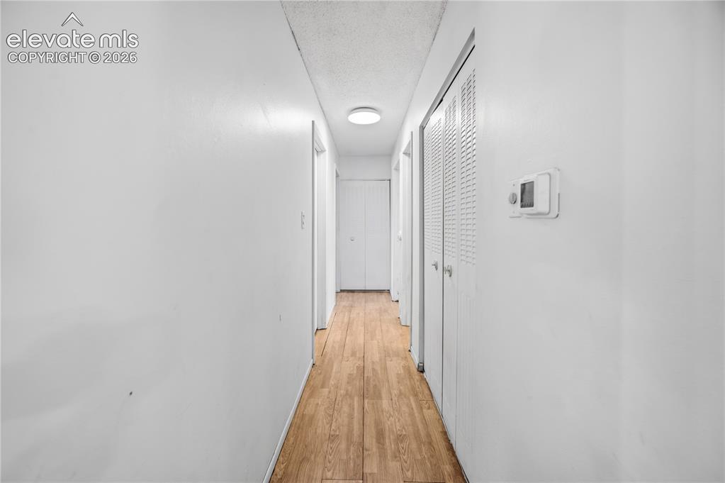 Image 15 of 35: Hallway featuring wood-finish flooring, white walls, and recessed lighting