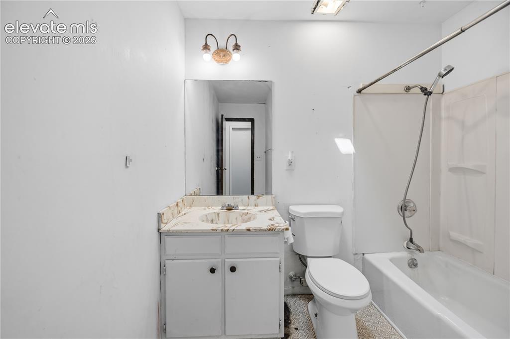 Image 16 of 35: Bathroom featuring a vanity with a countertop, integrated sink, and cabinet