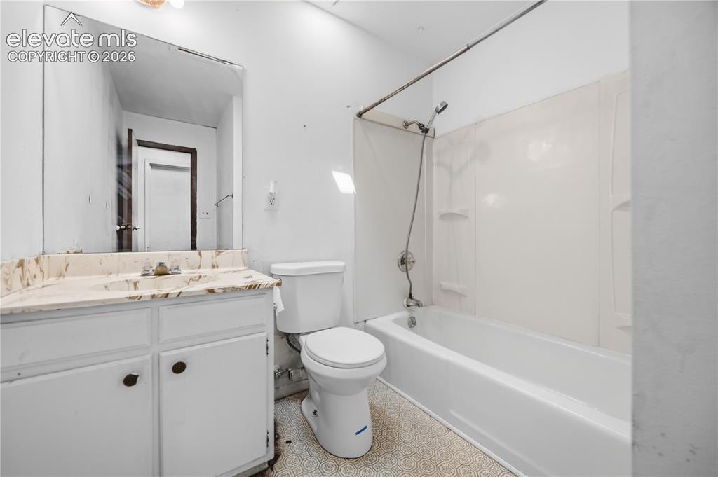 Image 17 of 35: Bathroom featuring a vanity with a light-toned countertop, a built-in sink,