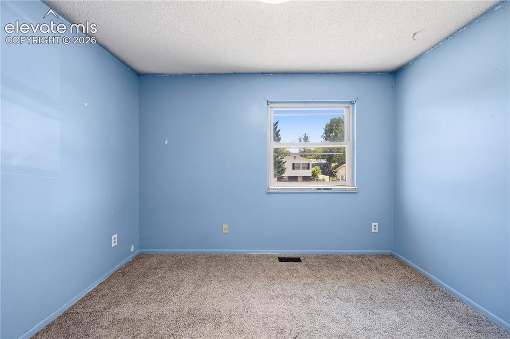 Image 19 of 35: Carpeted flooring with a white window frame and pop-textured ceiling