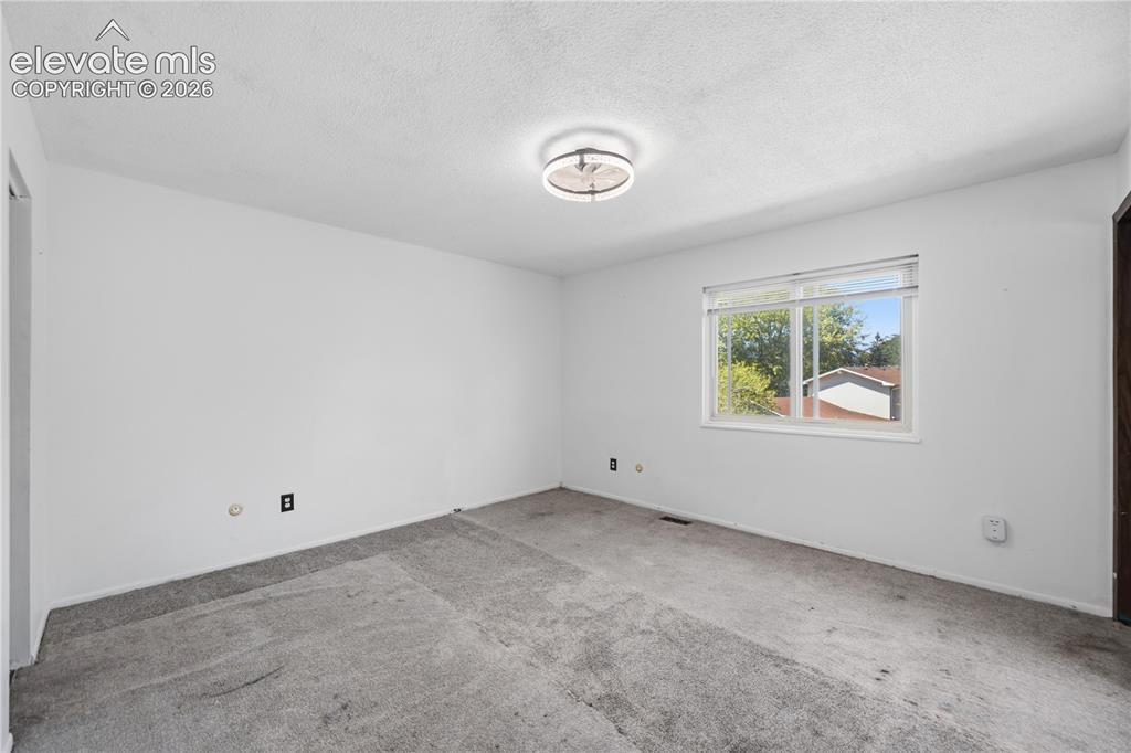 Image 21 of 35: Neutral wall color with a window providing natural light and a ceiling-moun