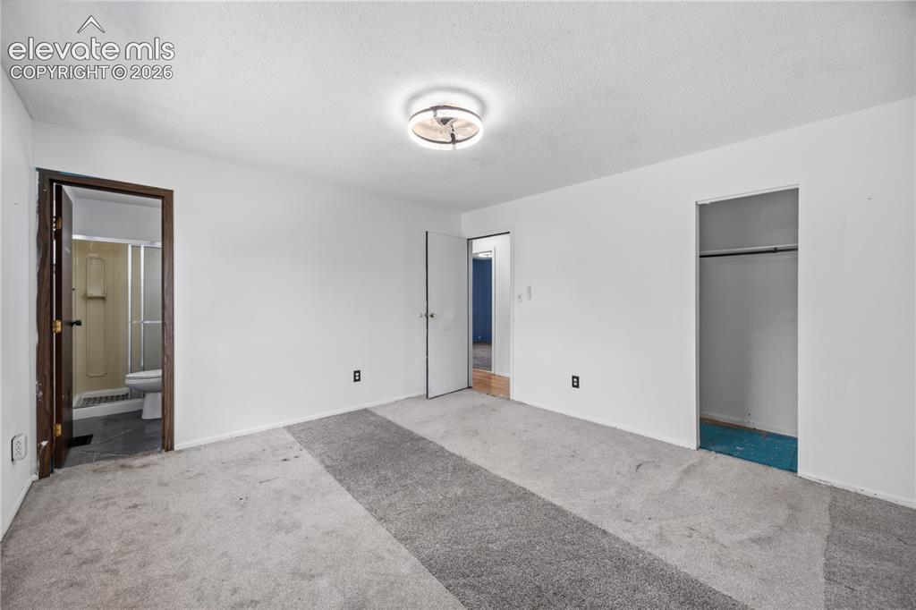 Image 23 of 35: Spacious room with overhead lighting, a built-in closet, and direct bathroo