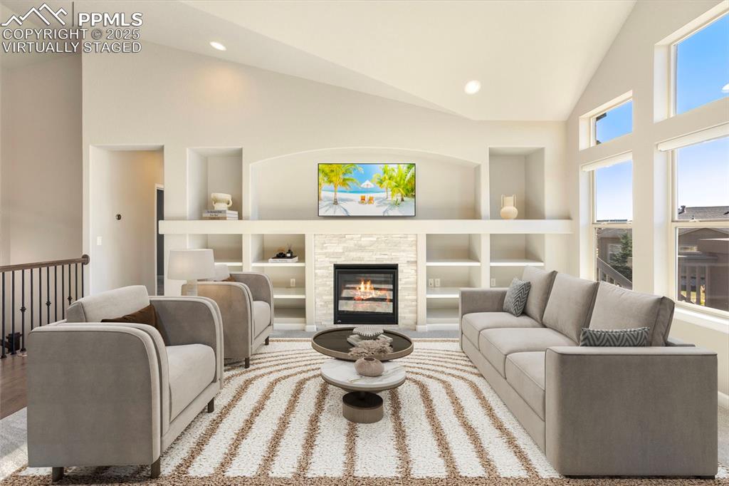 Image 10 of 48: Virtually Staged. Living area with high vaulted ceiling, a fireplace, built