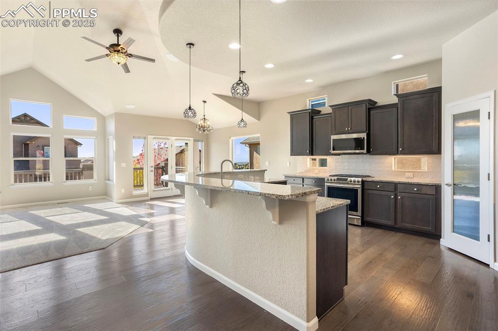 Image 12 of 48: Kitchen with appliances with stainless steel finishes, light stone counters