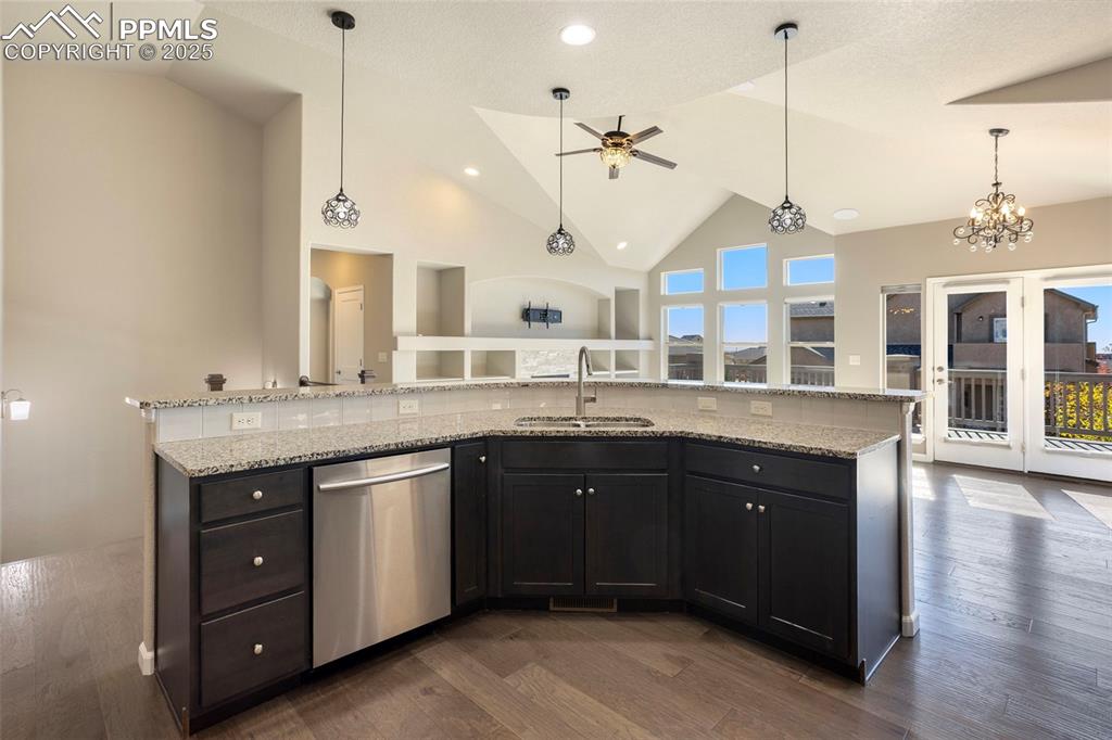Image 14 of 48: Kitchen featuring high vaulted ceiling, pendant lighting, stainless steel d