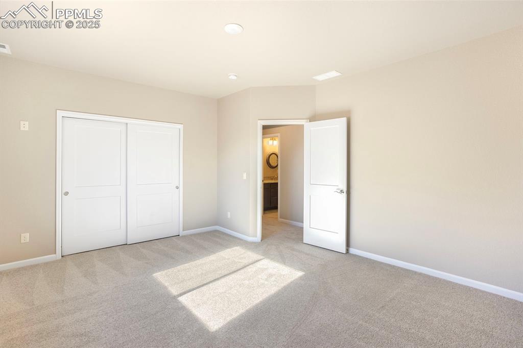 Image 28 of 48: Unfurnished bedroom with light colored carpet and a closet