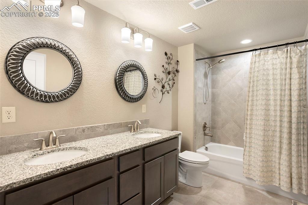 Image 29 of 48: Full bath with shower / tub combo, a textured wall, double vanity, a textur
