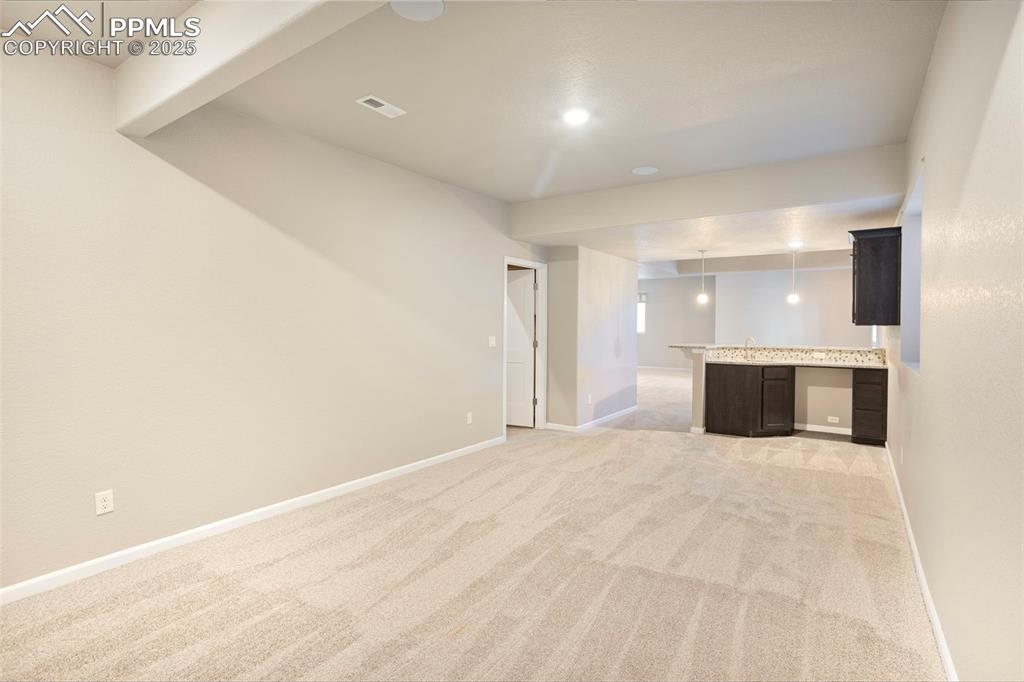 Image 37 of 48: Unfurnished living room featuring light colored carpet and recessed lightin
