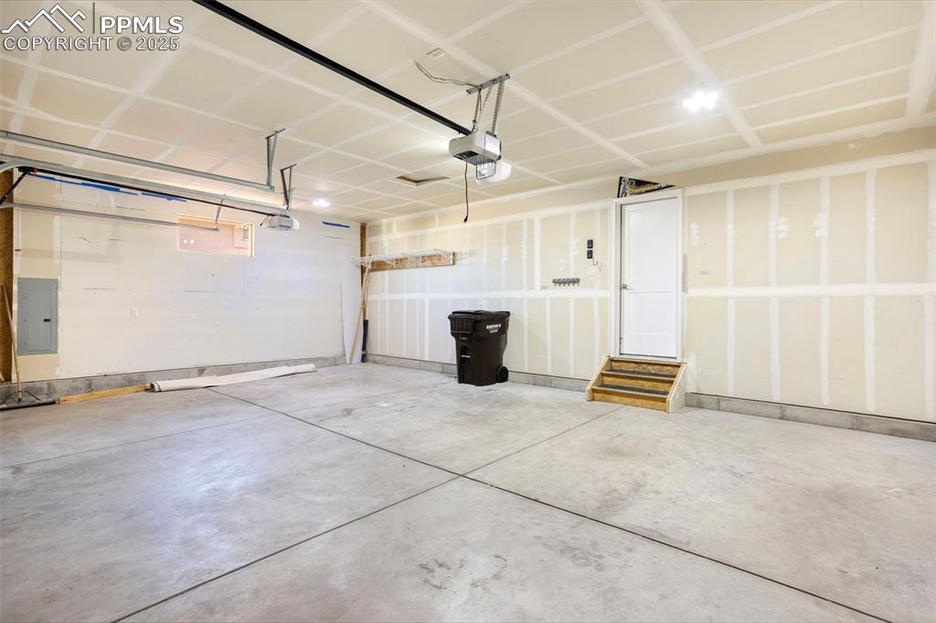 Image 47 of 48: Garage with electric panel and a garage door opener