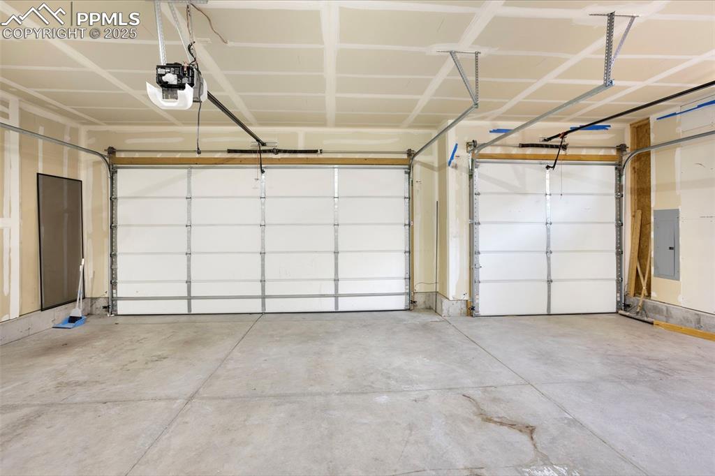Image 48 of 48: Garage featuring electric panel and a garage door opener