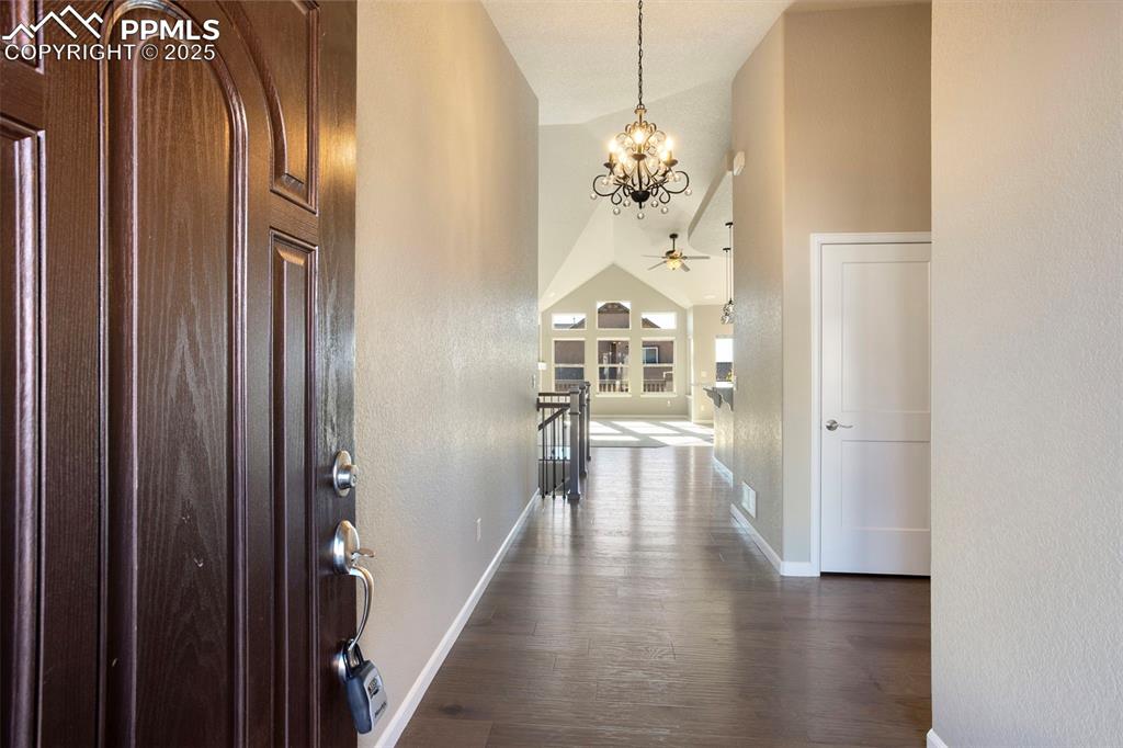 Image 5 of 48: Foyer entrance featuring vaulted ceiling, dark wood-style floors, a texture