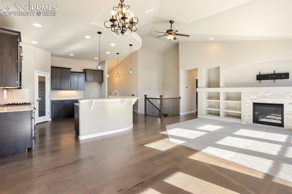 Image 8 of 48: Kitchen featuring light stone countertops, open floor plan, a chandelier, a