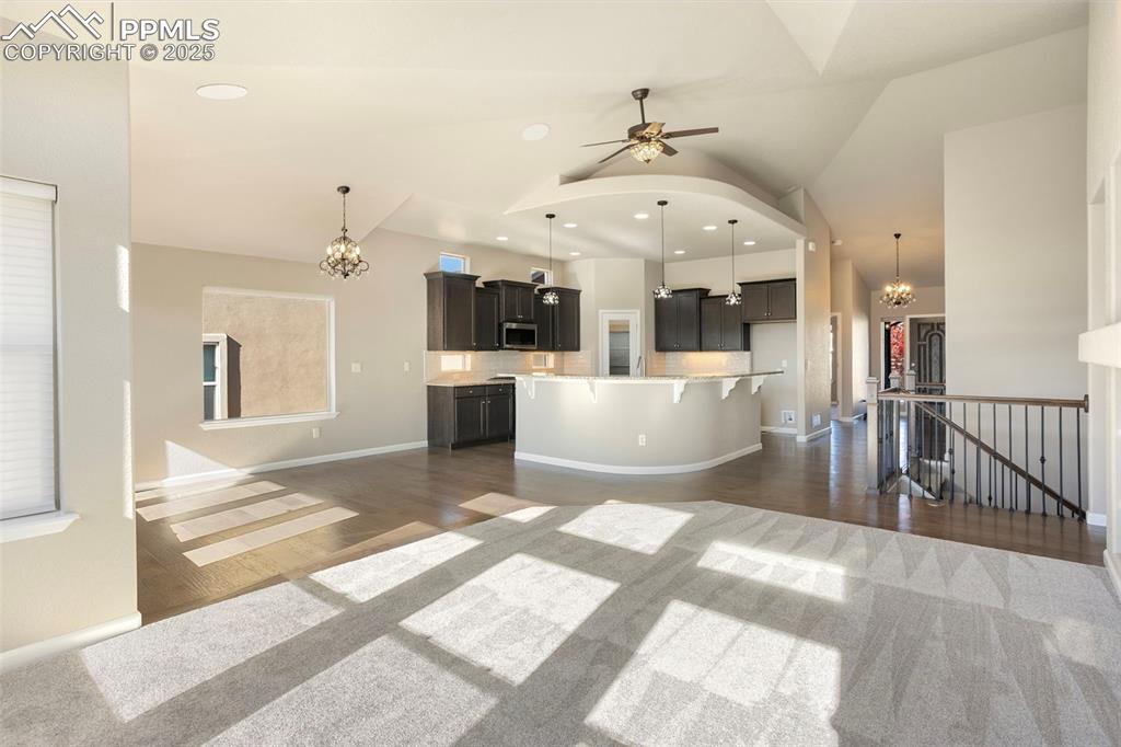 Image 9 of 48: Unfurnished living room featuring a chandelier, dark wood-style floors, a c
