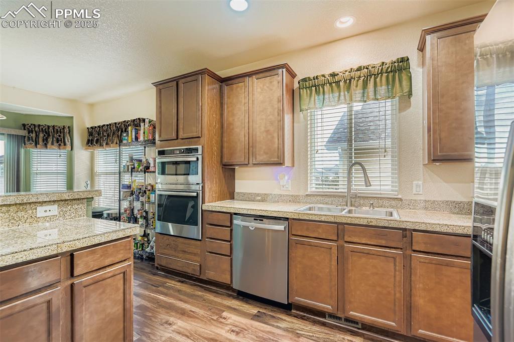 Image 12 of 29: Kitchen featuring granite tile countertops, appliances with stainless steel