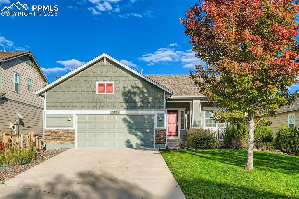 Image 2 of 29: Craftsman-style house with stone siding, concrete driveway, and a front law