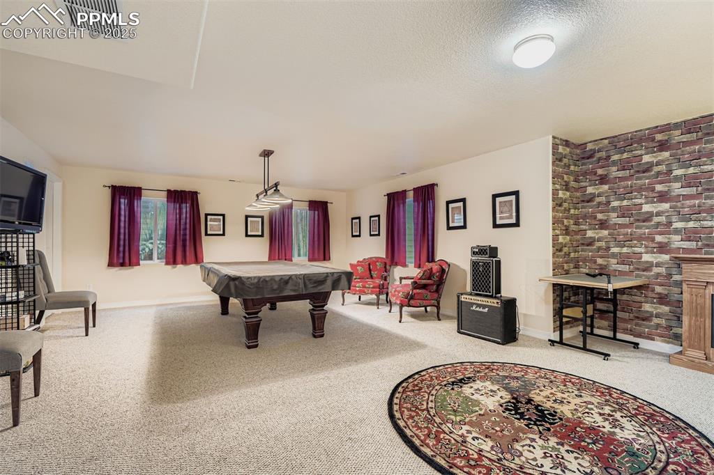 Image 20 of 29: Recreation room featuring pool table and electric fireplace in basement