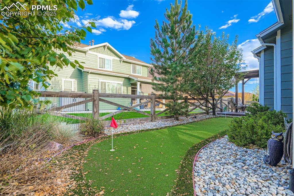 Image 29 of 29: Fenced backyard featuring a putting area