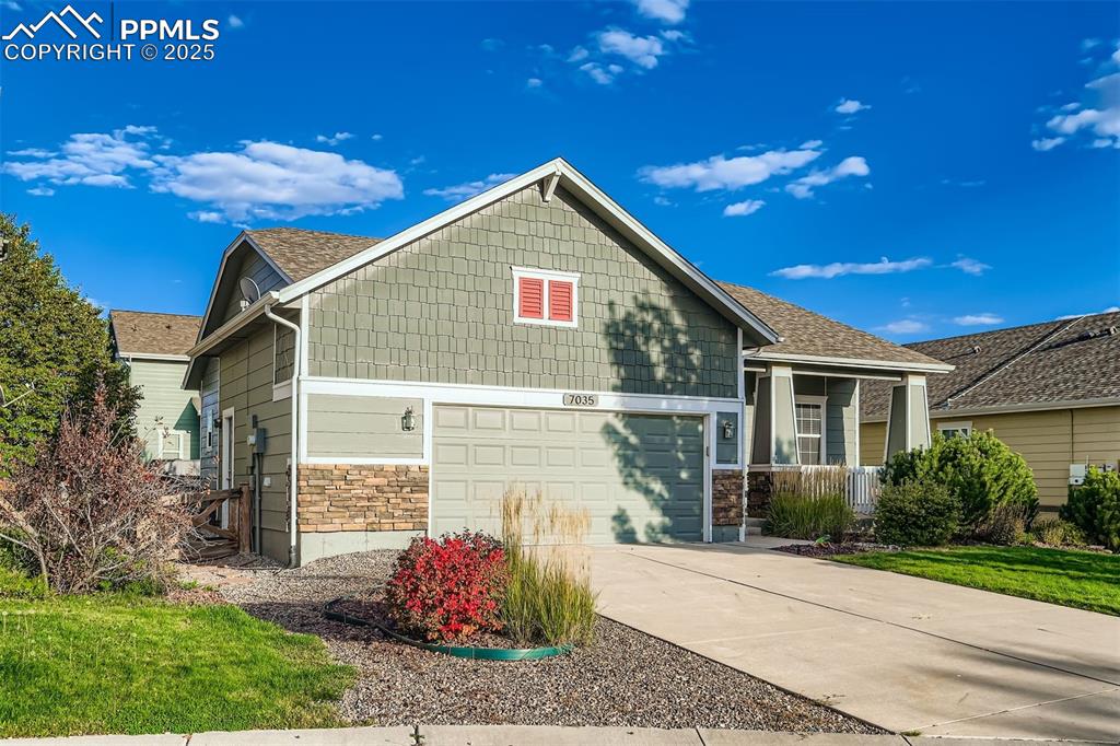 Image 3 of 29: Craftsman house featuring stone siding, a garage, driveway, and a shingled 