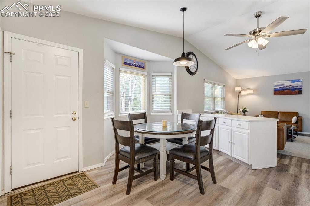 Image 10 of 36: Dining area featuring light wood finished floors, lofted ceiling, and a cei