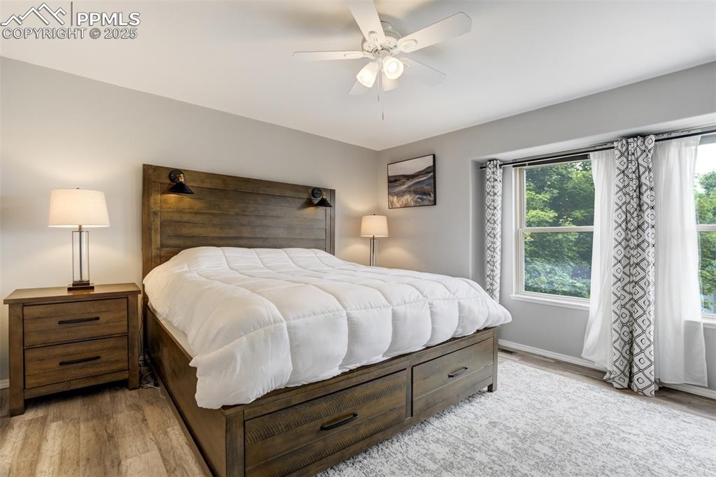 Image 14 of 36: Bedroom featuring light wood finished floors and a ceiling fan