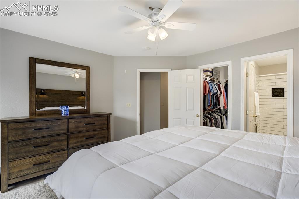 Image 17 of 36: Bedroom with a walk in closet, ensuite bathroom, and a ceiling fan