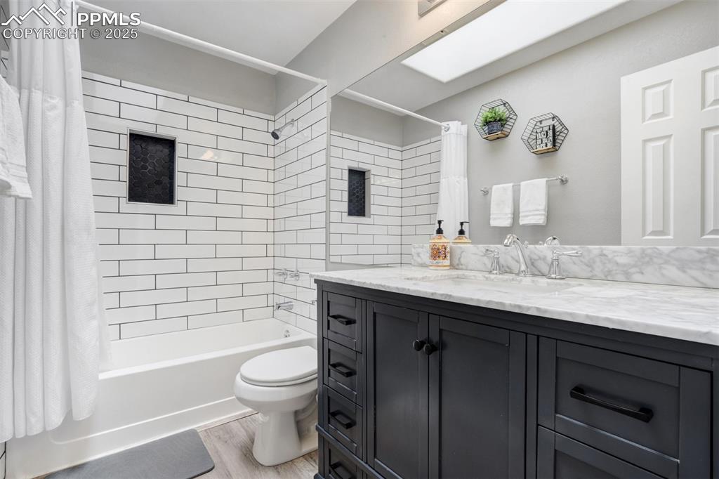 Image 22 of 36: Bathroom featuring vanity, shower / bathtub combination with curtain, and w