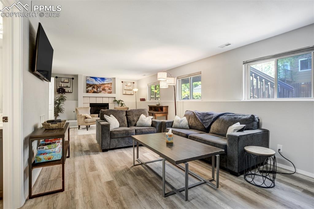 Image 23 of 36: Living area featuring light wood finished floors and a tile fireplace