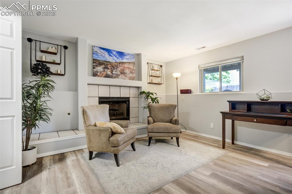 Image 25 of 36: Sitting room featuring wood finished floors and a fireplace
