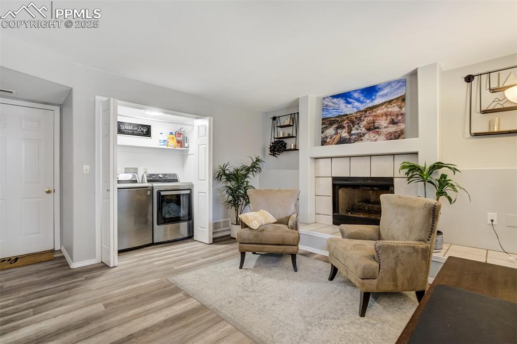 Image 26 of 36: Living area featuring washer and dryer, light wood-type flooring, and a fir