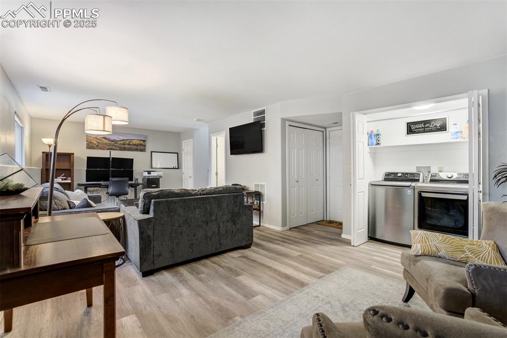 Image 28 of 36: Living room featuring light wood-style floors and washer and clothes dryer