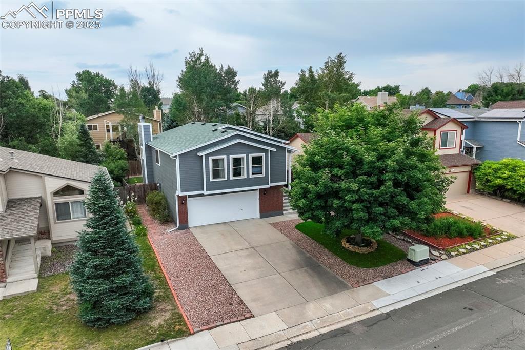Image 35 of 36: View of front of property with concrete driveway, an attached garage, a res