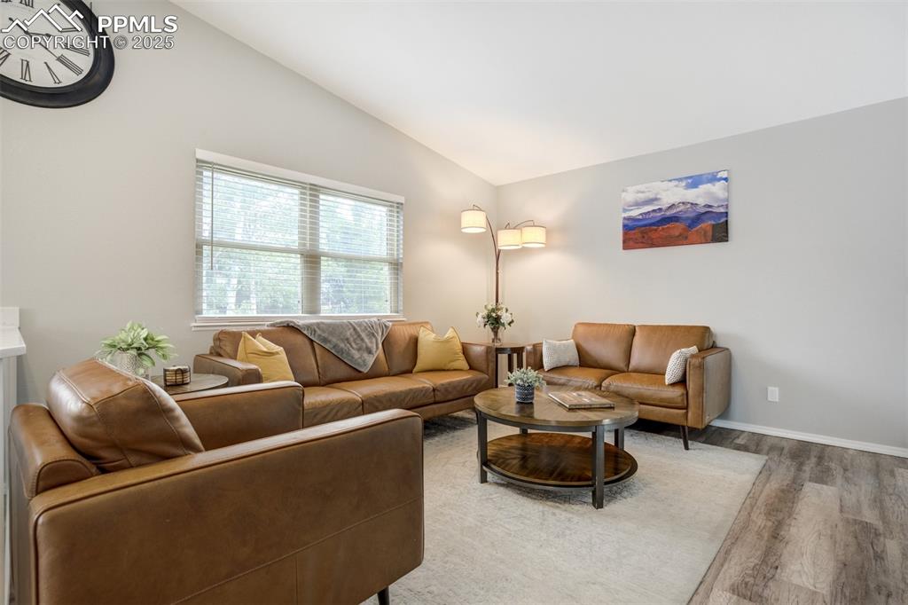 Image 7 of 36: Living room featuring vaulted ceiling and light wood finished floors