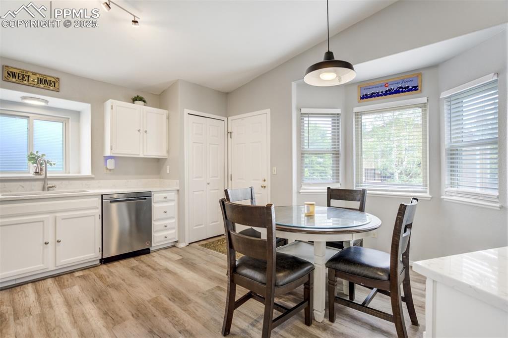 Image 9 of 36: Dining space with light wood-style flooring and vaulted ceiling