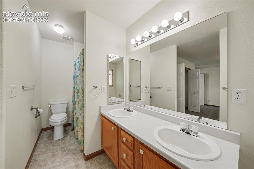 Image 18 of 33: En Suite Primary Bath Double Sink, Toilet and Shower