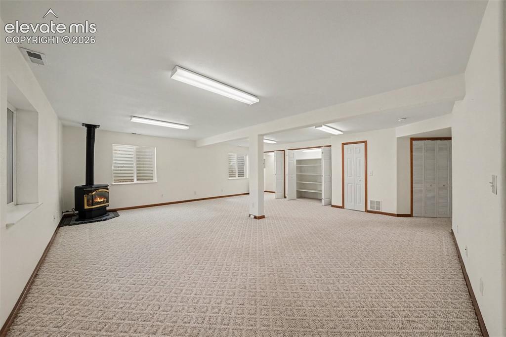Image 22 of 33: Basement Family Room with Gas Fireplace and lots of storage