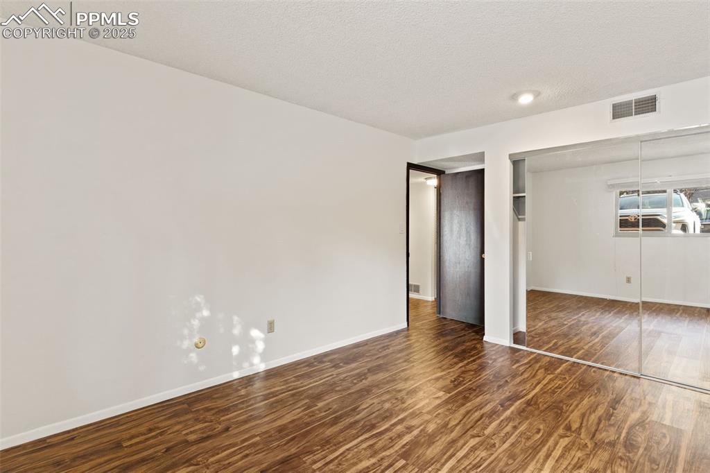 Image 12 of 20: Glass closet doors bring in natural light and expand the room visually