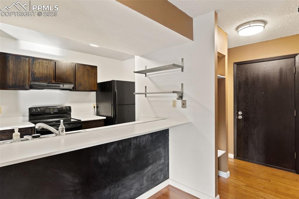 Image 5 of 20: Chalk wall under breakfast bar and built-in open shelving