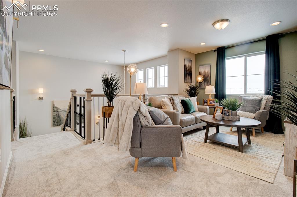 Image 22 of 32: Living room with light colored carpet and recessed lighting