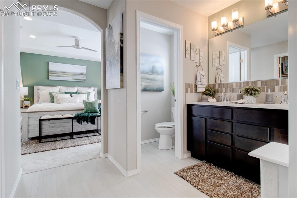 Image 27 of 32: Ensuite bathroom featuring double vanity, ceiling fan, recessed lighting, a