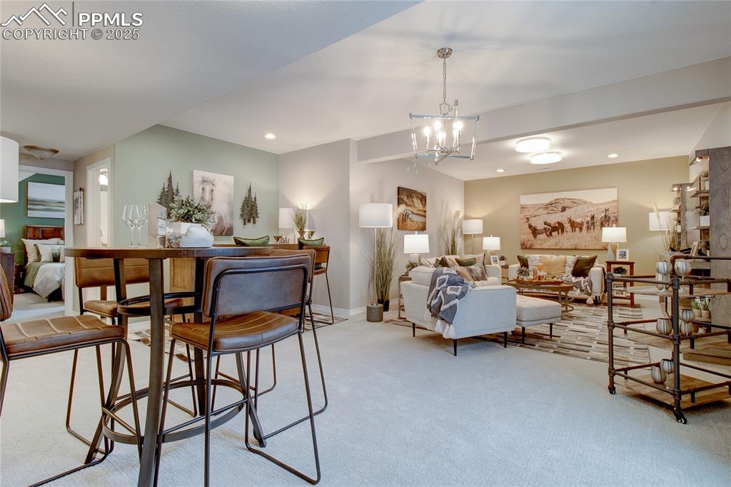 Image 28 of 32: Dining area featuring light carpet, a chandelier, and recessed lighting